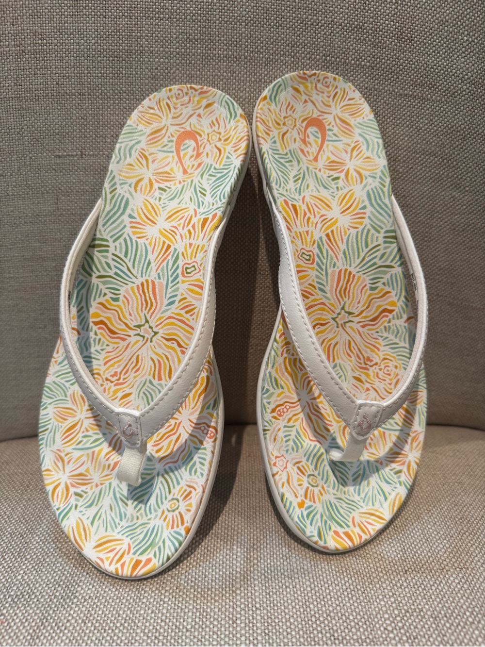 OluKai women’s Cream Strap Flip Flops with Floral Multi-Color Footbed